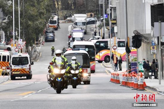 资料图：2月20日上午，约10时18分，接载“钻石公主”号上香港居民的旅游巴驶入香港火炭骏洋邨。首架接载“钻石公主”号邮轮的106位香港居民专机抵达香港国际机场，随即被送往香港火炭骏洋邨进行为期14天的强制检疫。而在骏洋邨，大批警员在路口把守，邨内第一批500个用作检疫中心的单位较早前已经准备就绪。中新社记者 李志华 摄