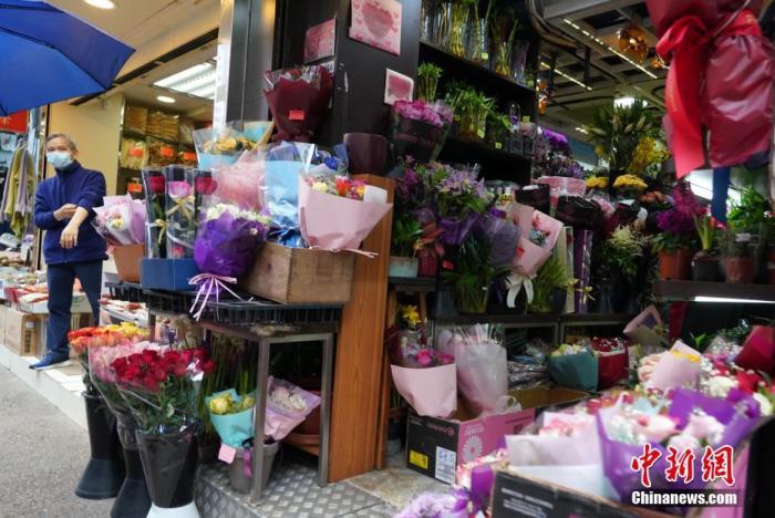 2月14日情人节，香港湾仔一家鲜花店等待顾客上门。有花店负责人表示，由于新冠肺炎疫情持续，许多职员仍在家中办公，鲜花预定生意明显减少。 中新社记者 张炜 摄